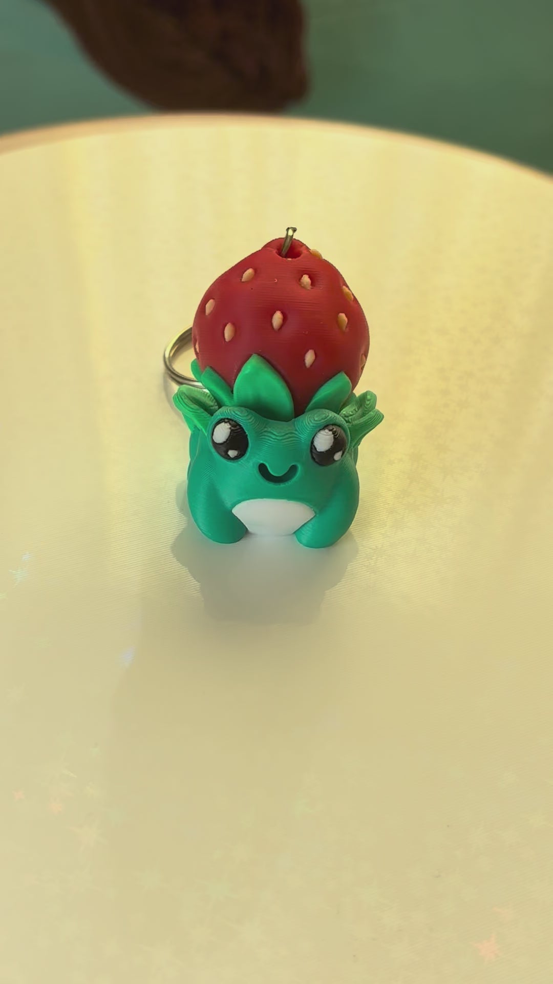 Strawberry hat frog keychain fidget clicker 3D printed teal frog wearing strawberry